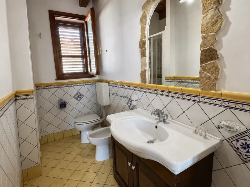 Bagno con specchio ad arco in pietra